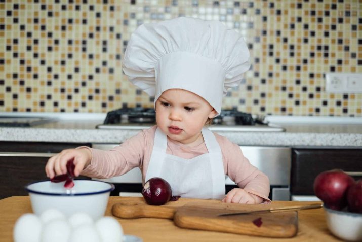 Nominated. A girl in a chef's hat cleans onions in the kitchen